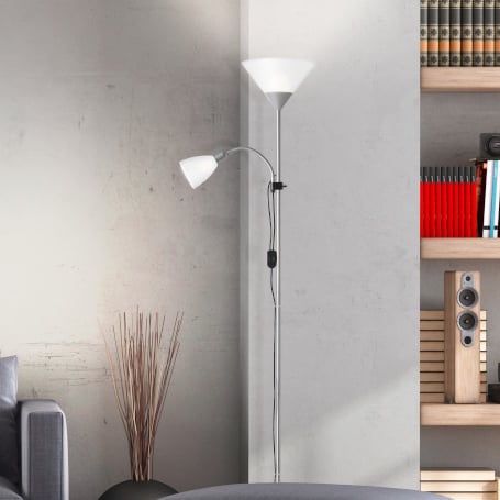 Eine moderne, eingeschaltete Stehleuchte aus Chrom mit einem nach oben gerichteten, weißen Deckenfluter-Schirm und einer flexibel einstellbaren, kleineren Leselampe steht in einer Zimmerecke neben einem Bücherregal.