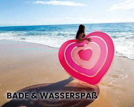 Das Bild zeigt eine Frau, die am Strand mit dem Meer im Hintergrund steht. Sie hält ein großes, pinkfarbenes Herz aus Schwimmreifen oder -flößen. Das Wetter ist sonnig, und die Szene vermittelt ein Gefühl von Spaß und Freude am Wasser. Unten im Bild steht der Text "BADE & WASSERSPASS". Bei Klick auf das Bild werden Produkte der Marke Intex aus dem Bereich Bade und Wasserspass aufgerufen.