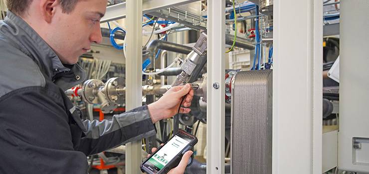 Ein Techniker überprüft eine Maschine in einer industriellen Anlage.