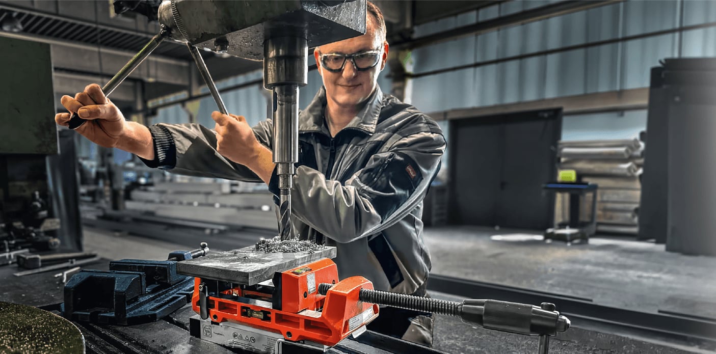Eine Person mit Schutzhandschuhen bedient eine FLIR Wärmebildkamera, um einen goldenen Elektromotor in einer Industrieumgebung zu überprüfen.