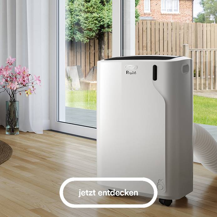 Das Bild zeigt einen weißen, mobilen De'Longhi Pinguino Klimaanlage auf einem hellen Holzboden vor einer Terrassentür mit weißen Vorhängen, durch die man einen Garten mit einem Holzzaun und einem Haus sieht, sowie einen hervorgehobenen Button mit der Aufschrift "jetzt entdecken".