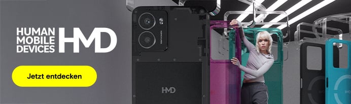 Eine Person mit kurzen, blonden Haaren, bekleidet mit einem hellgrauen Oberteil, steht in einer stilisierten Umgebung mit mehreren vertikal hängenden, verschiedenfarbigen Smartphone-Hüllen.