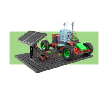 Ein kleines, schwarzes Modellauto mit grünen Rädern und roten Bauteilen von fischertechnik.