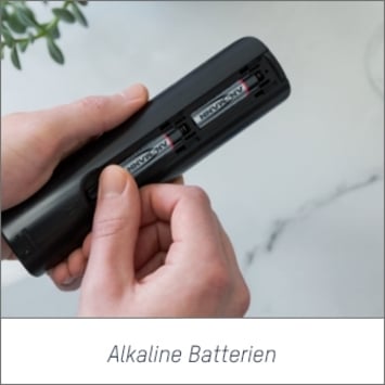 Das Bild zeigt die Hände einer Person, die ein Gerät halten, in das alkalische Batterien eingelegt werden. Bei Klick auf das Bild werden die Ansmann Lithium Alkaline Batterien aufgerufen.