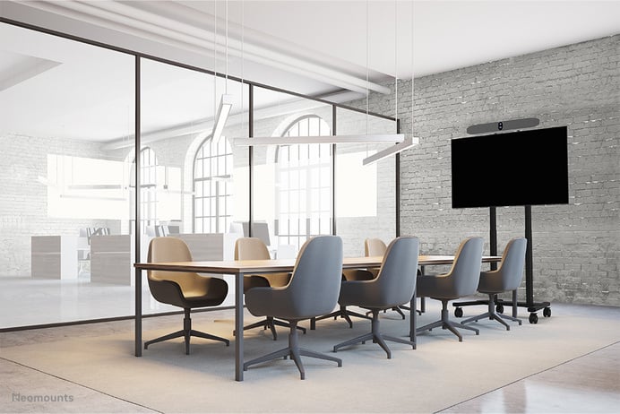 Ein Bild eines modernen Konferenzraums mit einem großen Fernseher auf einem Ständer.