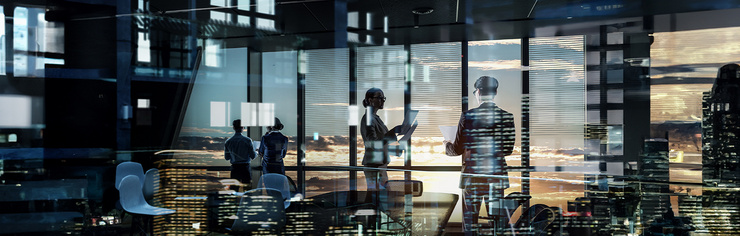 Personen stehen in Büro mit Glasfront