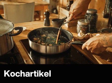 Eine Person brät Pilze und Kräuter in einer Pfanne auf einem modernen Induktionskochfeld in einer hellen Küche an.