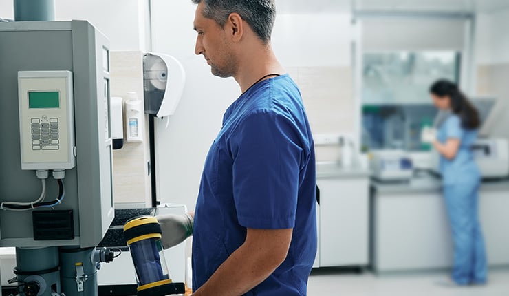 Abb. Laborassistent sendet die Ergebnisse einer Laboruntersuchung per Rohrpost weiter