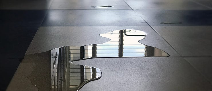 Wasserpfütze auf Boden als Folge von Leckagen - Frühwarnsysteme