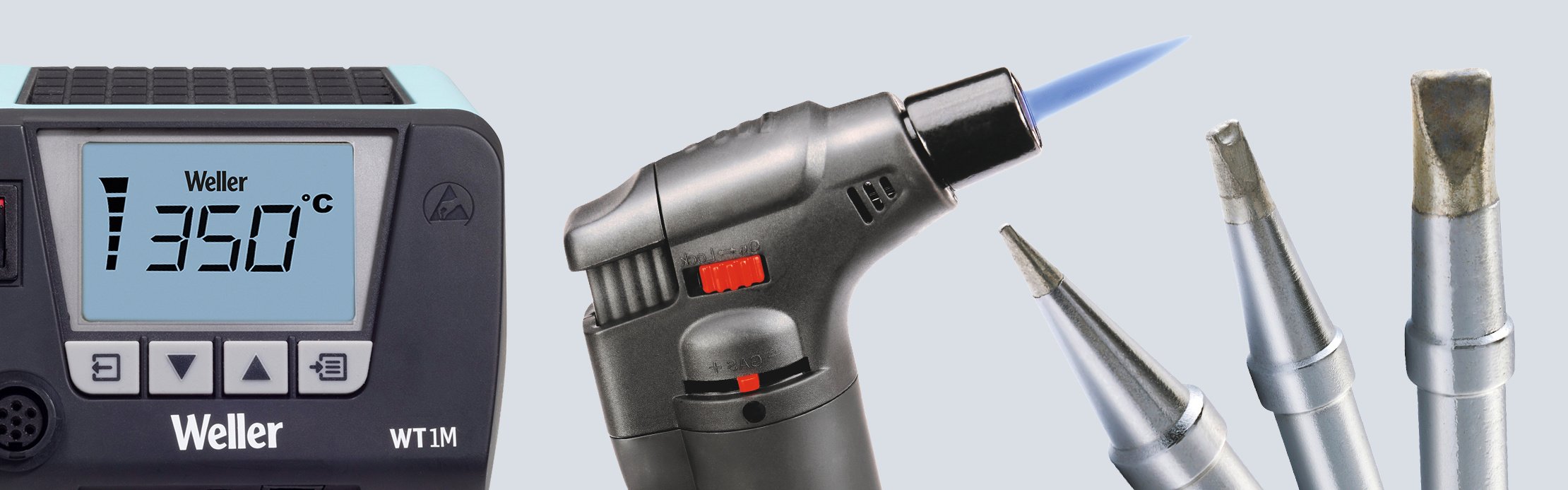 Anzeige einer Lötstation, daneben ein Gaslötbrenner mit blauer Flamme sowie mehrere unterschiedliche Lötspitzen.