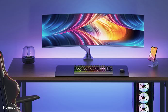 Ein Bild von einem eleganten, modernen Gaming-Setup mit einem gebogenen Monitor und Umgebungsbeleuchtung.
