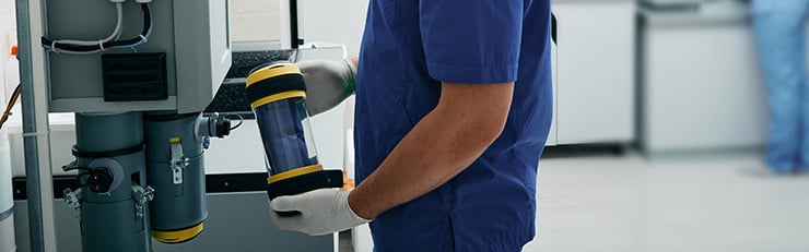 Abb. Laborassistent sendet die Ergebnisse einer Laboruntersuchung per Rohrpost weiter