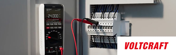 Nahaufnahme von einem Schaltschrank mit einem Multimeter und das Logo von VOLTCRAFT ist unten rechts abgebildet