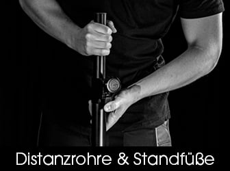 Eine detailreiche Schwarz-Weiß-Aufnahme, die zeigt, wie eine Person ein schwarzes Distanzrohr mit den Händen manuell fixiert oder justiert.