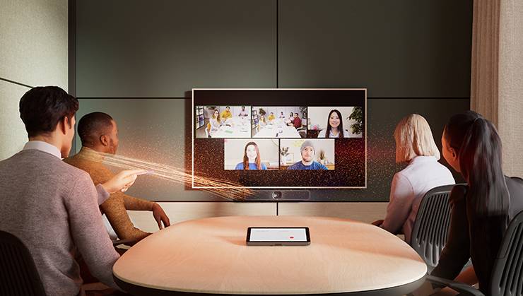 Gruppe von Personen nimmt an einer Videokonferenz teil, dargestellt auf einem großen Bildschirm im Besprechungsraum.