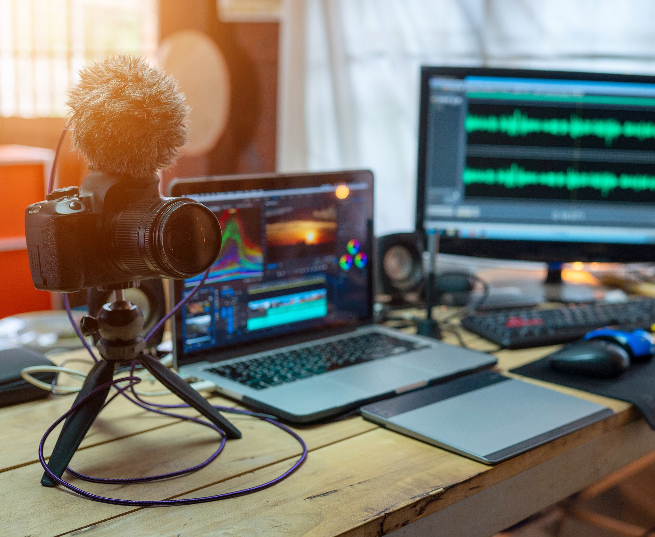 Eine Person mit Kopfhörern und Mikrofon spricht in ein professionelles Aufnahme-Setup