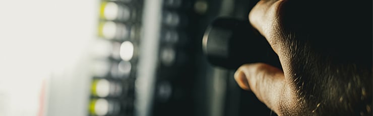 Techniker mit Taschenlampe die Sicherungen am prüfen.