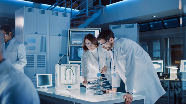 Forschende in weissen Laborkitteln analysieren medizinische Daten mithilfe moderner Technologie und 3D-Druck – KI-gestützte Forschung im Gesundheitswesen.