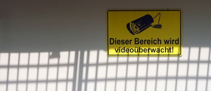 Warnschild mit Kamera, das besagt, dass der Bereich videoüberwacht wird.
