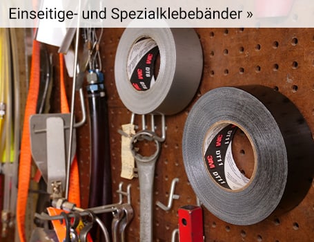 In einem Industriegebäude sind zwei große, zylindrische braune Fässer auf einer Holzpalette zu sehen, die mit einem schwarzen Band zusammengehalten werden, wobei ein Teil eines Hubwagens mit grünem Griff und der Aufschrift "duct tape" im Vordergrund sichtbar ist; der Text "Einseitige Klebebänder »" im oberen Bereich des Bildes weist auf eine Weiterleitung hin.