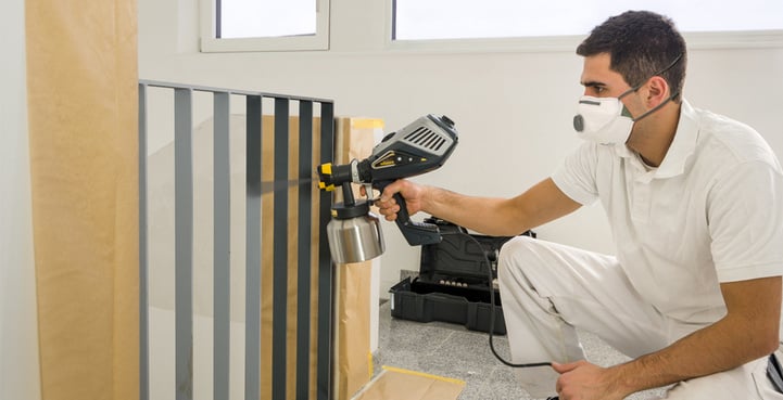 Ein Maler verwendet ein Wagner Finish Control 3500 Sprühgerät zum präzisen Lackieren eines Geländers.
