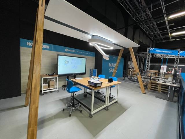 Moderner Lehrraum-Musterbereich mit Smartboard, flexiblen Arbeitstischen und ergonomischen Stühlen.