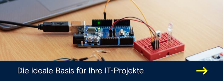 Arduino-Entwicklungsboard auf einem Schreibtisch, per USB verbunden und mit Kabeln an ein rotes Steckbrett mit LED angeschlossen.