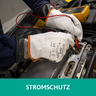 Das Bild zeigt einen Autoelektroniker mit Schutzhandschuhen, der im Motorraum an einem elektrischen Bauteil arbeitet. Beim Klick auf das Bild werden Schutzhandschuhe aufgerufen, die Stromschutz bieten.