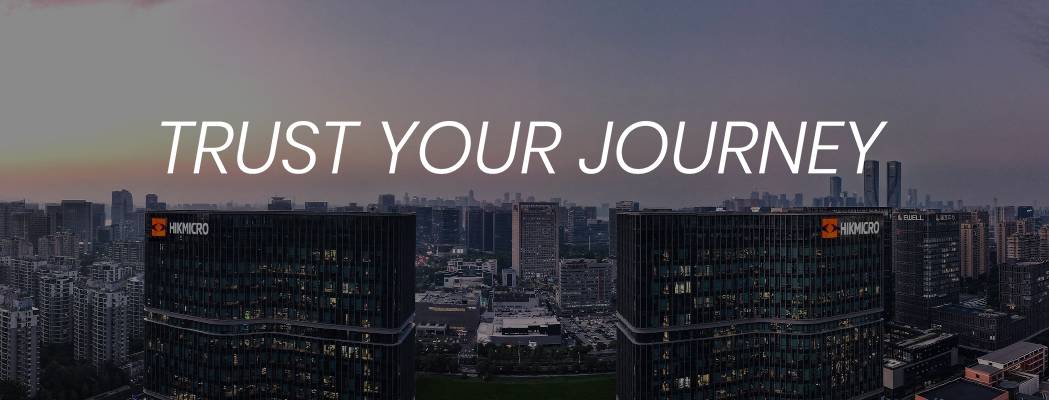 Ein Banner zeigt eine Skyline bei Dämmerung mit zwei markanten, beleuchteten Hochhäusern im Vordergrund, die das Hikmicro-Logo tragen, überschrieben mit dem weißen Schriftzug „TRUST YOUR JOURNEY“.