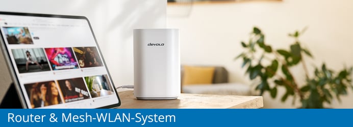 Ein weißer devolo Router steht auf einer Holzoberfläche neben einem eingeschalteten Tablet, untertitelt mit dem Schriftzug „Router & Mesh-WLAN-System“ auf blauem Hintergrund.