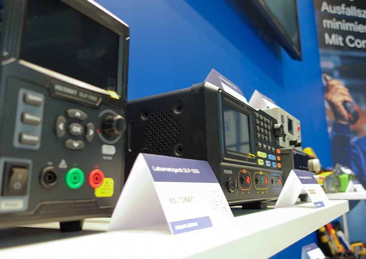 Eine Nahaufnahme von Labornetzgeräten auf einem Regal und kleinen Klappkarten