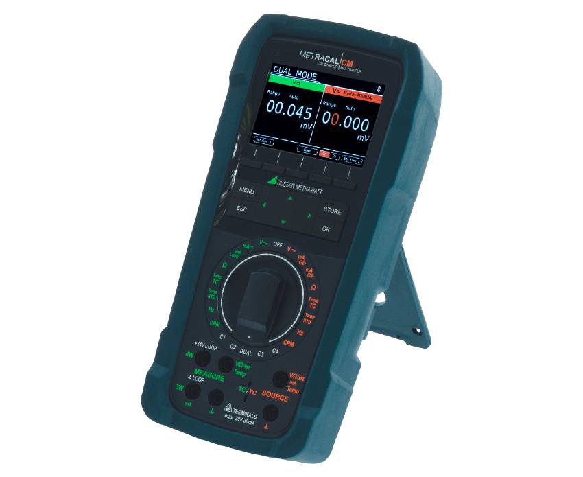 Ein digitales Gossen Metrawatt METRACAL MC Multimeter und Kalibrator in einem robusten dunkelblauen Gehäuse mit ausklappbarem Standfuß, großem Farbdisplay und zentralem Drehschalter auf weißem Hintergrund.