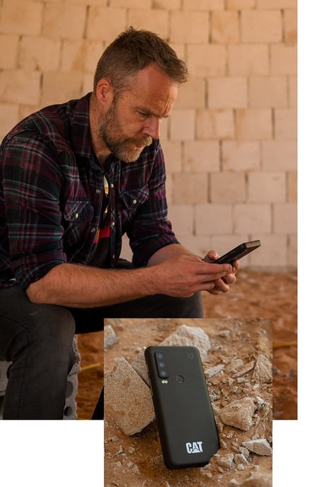 Mann nutzt robustes CAT S75 5G-Outdoor-Smartphone, ein weiteres CAT Handy liegt auf steinigem Untergrund bereit.