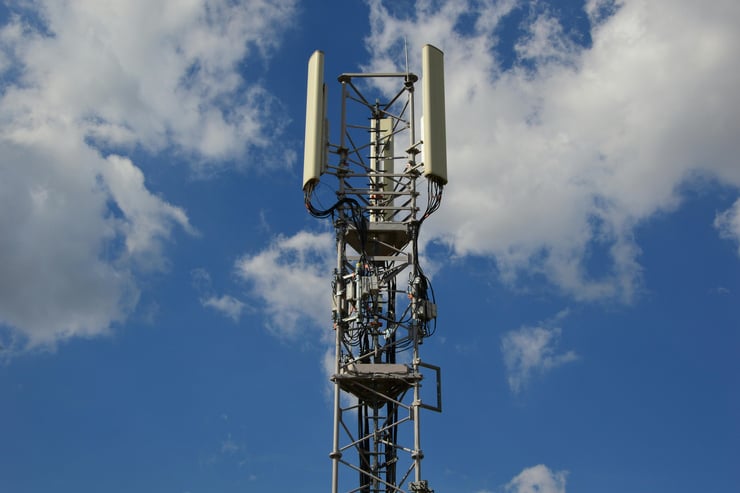 5G-Funkmast mit Antennen vor blauem Himmel