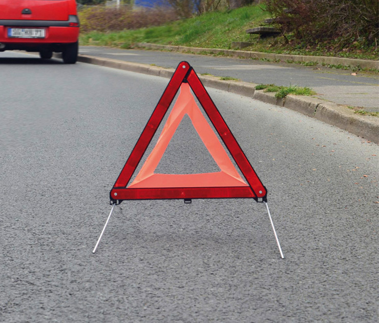 Mehrere blaue E Auto Ladesäulen in einer modernen Tiefgarage, im Vordergrund eine Ladestation mit angeschlossenem Ladekabel und Not Aus Schalter.