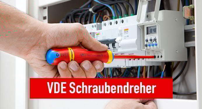 Das Bild zeigt einen Elektriker der mit einem VDE Schraubendreher eine Zeitschaltuhr auf der Hutschiene eines Installationsschrankes einbaut. Bei Klick auf das Bild werden VDE Schraubendreher aufgerufen.