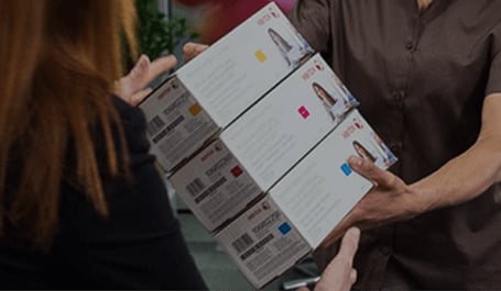 Das Bild zeigt einen Kurierfahrer, der einer Frau drei original Xerox Tonerkasetten im Karton überreicht. Beim Klick auf das Bild wird die Unterseite Original Xerox Toner aufgerufen.