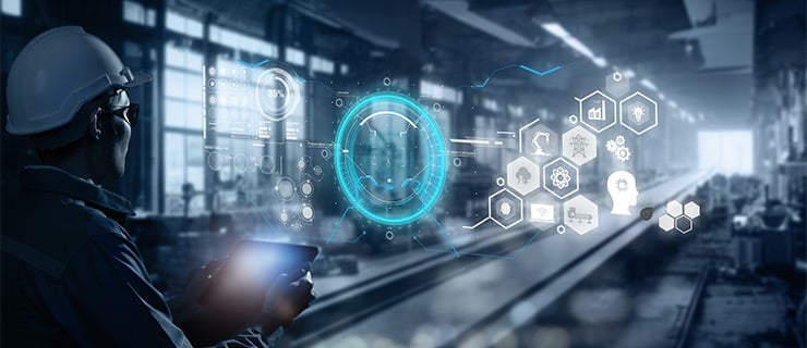 Ein Arbeiter mit Helm nutzt ein Tablet in einer modernen Industriehalle mit digitalen Schnittstellen und Grafiken.