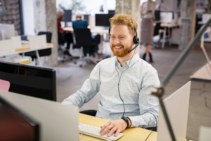 Mitarbeiter mit Headset arbeitet am Computer