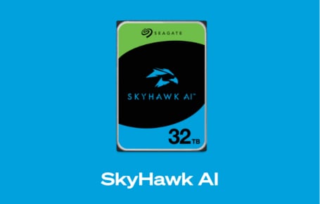 Ein hellblauer Kasten zeigt eine interne Festplatte mit einem grünen, schwarzen und hellblauen Aufkleber, der das SkyHawk-Logo und den Schriftzug "SkyHawk AI" trägt, darunter steht in weißer Schrift "Skyhawk AI".