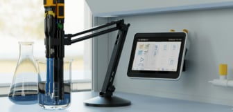 Ein digitales Labormessgerät der Serie MultiLab Pro IDS zeigt Analysedaten auf einem Touchscreen an, während Sensoren an einem Schwenkarm in ein mit blauer Flüssigkeit gefülltes Becherglas eintauchen.