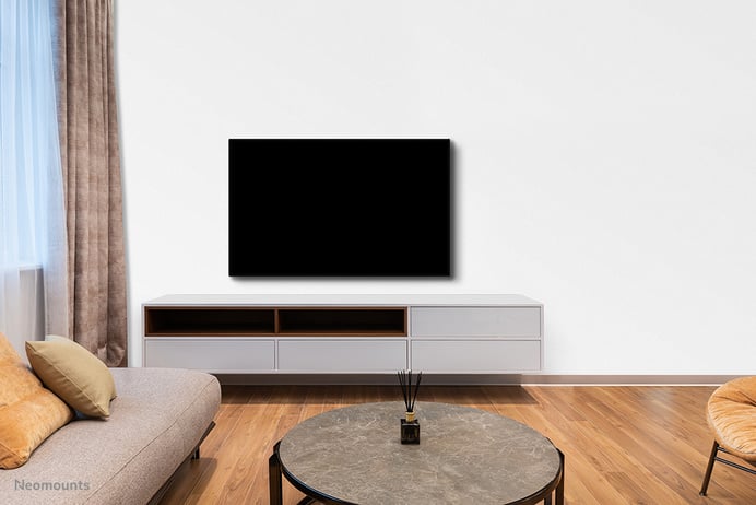 Ein Bild eines modernen Wohnzimmers zeigt einen Flachbildfernseher über einer niedrigen Medienkonsole.