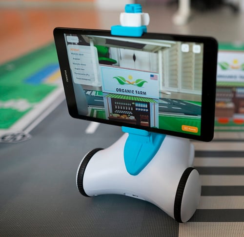 Ein Photon Roboter mit Tablet zeigt eine virtuelle organische Farm in Augmented Reality.