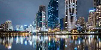 Das Bild zeigt die Skyline einer modernen Großstadt bei Nacht.