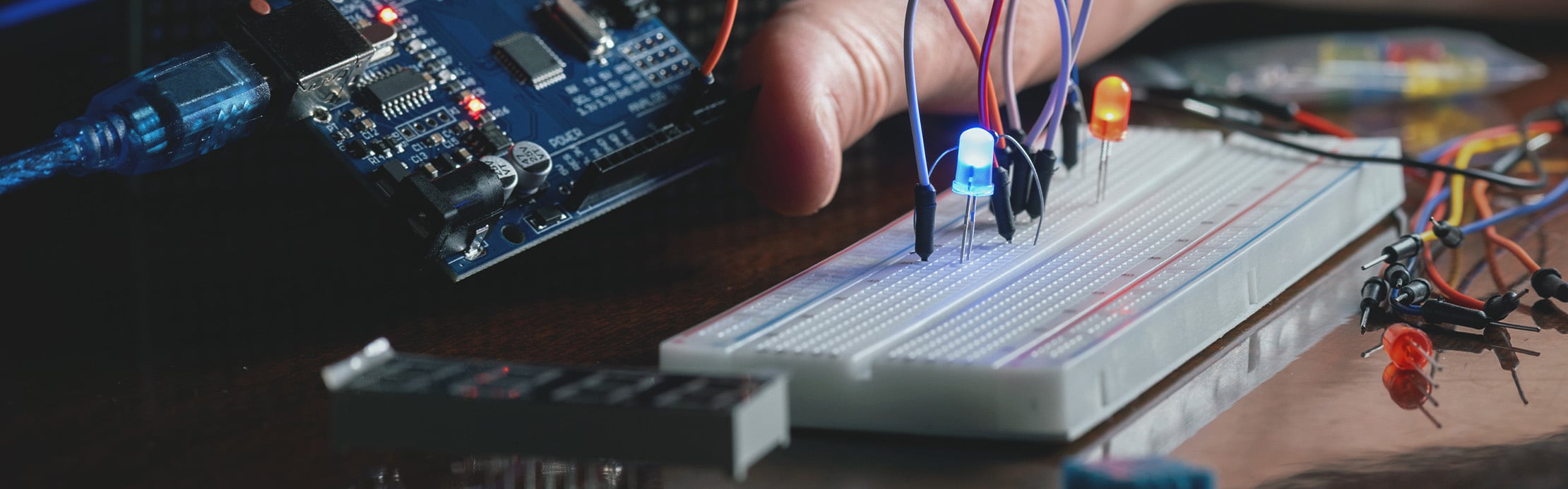 Entwicklungsboard mit angeschlossenem Steckbrett, leuchtenden LEDs und mehreren Verbindungskabeln