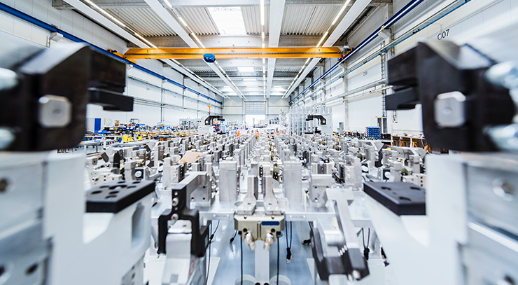 Vue intérieure d’un hall de production moderne avec de nombreuses machines et postes de travail.