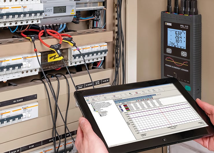 Un boîtier de fusibles en cours de mesure à l'aide d'une tablette.