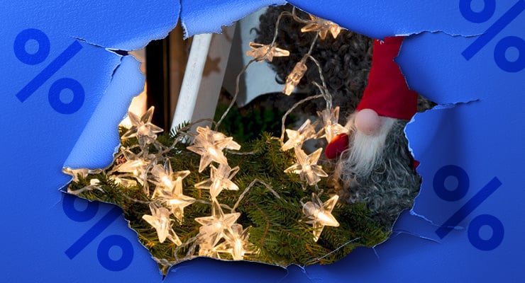 Une guirlande lumineuse avec des étoiles brillantes repose sur des branches de sapin derrière un fond bleu déchiré.