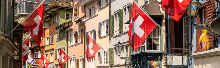 Ruelle d’une vieille ville suisse ornée de nombreux drapeaux suisses pour célébrer la fête nationale du 1er août.