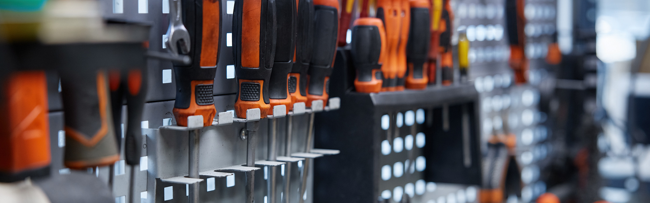 Des tournevis et des outils à main bien agencés sur un panneau à outils, pour un atelier bien organisé et un accès rapide à l'outil adéquat.